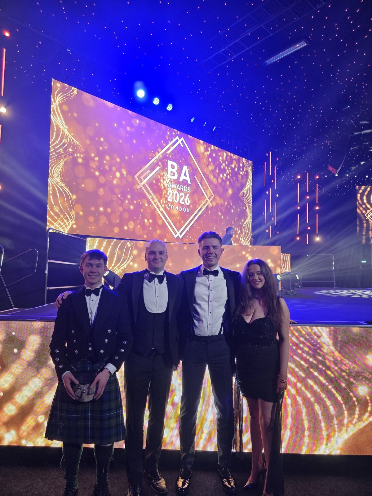 Four members of the HMG team in black tie and a kilt at the BA Awards 2026 in London
